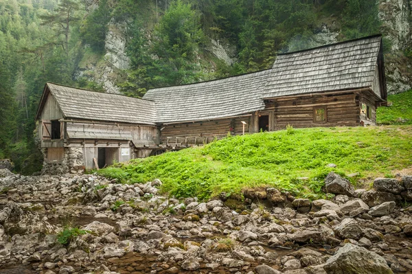 Cottage in legno in montagna con torrente — Foto Stock