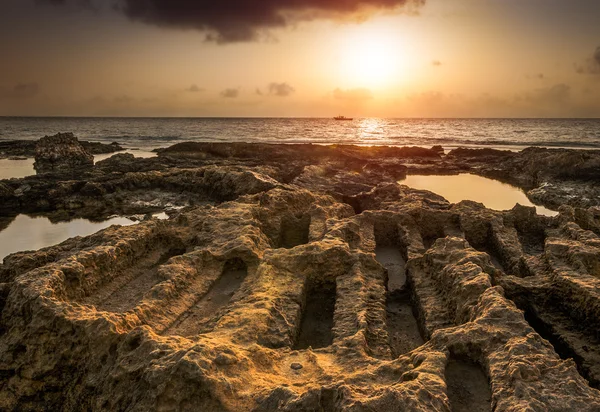 Puesta de sol sobre el mar y la costa rocosa con ruinas antiguas —  Fotos de Stock