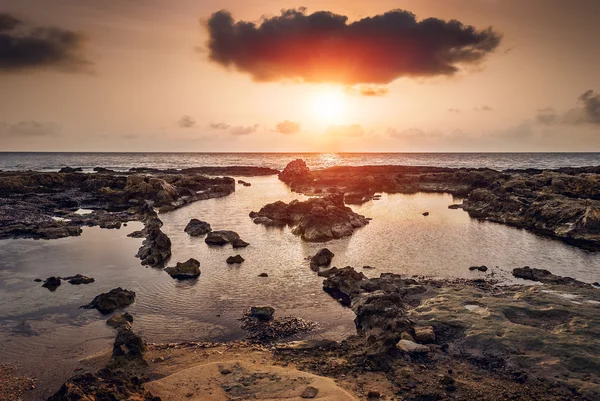 günbatımı üzerinde kayalık sahil ve deniz
