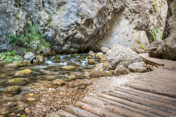 Arroyo bajo rocas con sendero de madera —  Fotos de Stock