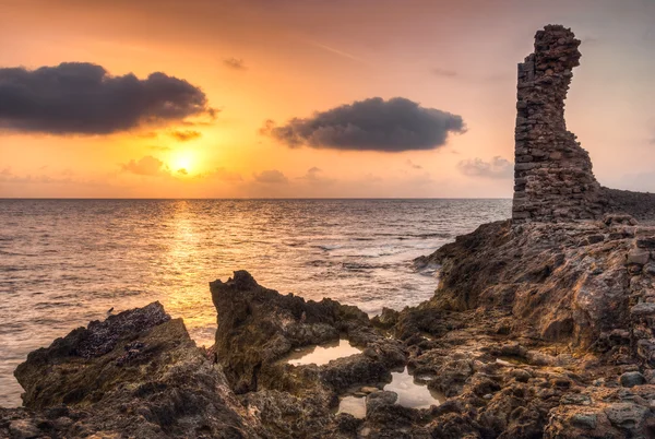 海と岩の海岸に沈む夕日 — ストック写真