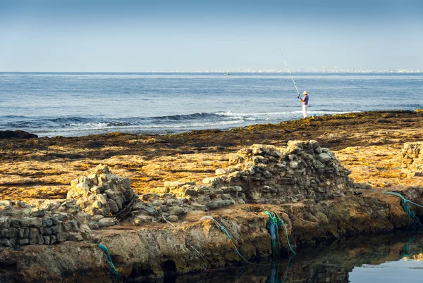 Costa rocosa y ver con pescador —  Fotos de Stock