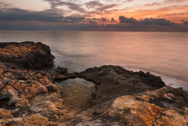 Plage rocheuse au coucher du soleil — Photo