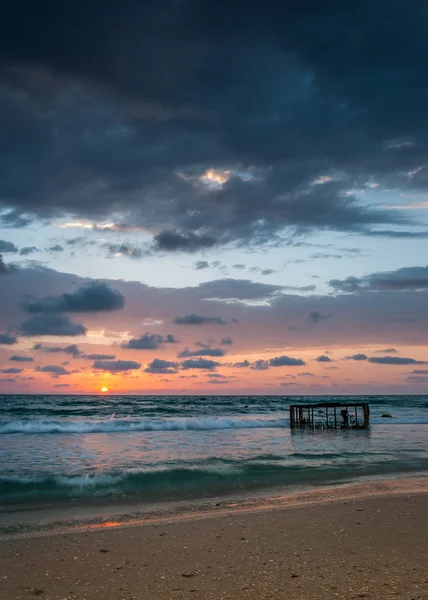 Playa tropical con jaula vacía en el mar al atardecer — Foto de Stock
