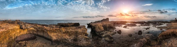 Puesta de sol sobre el mar y la costa rocosa con ruinas antiguas —  Fotos de Stock