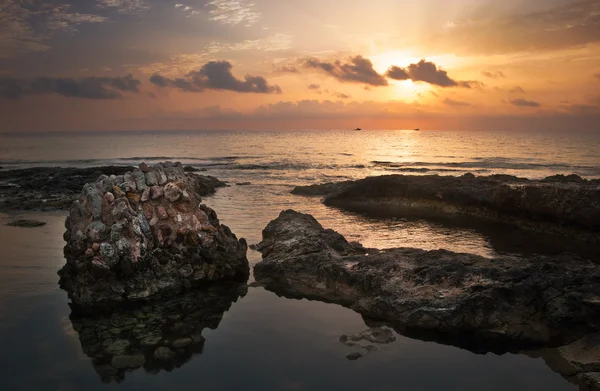 Tramonto sul mare e costa rocciosa con antiche rovine — Foto Stock