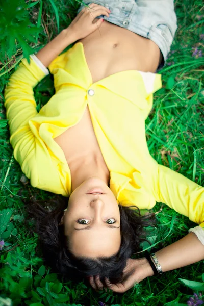 Vacker flicka liggande på en gräs — Stockfoto