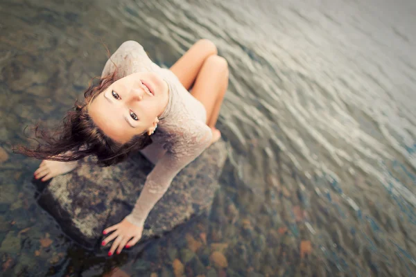 Triste chica flaca sentada en la piedra — Foto de Stock