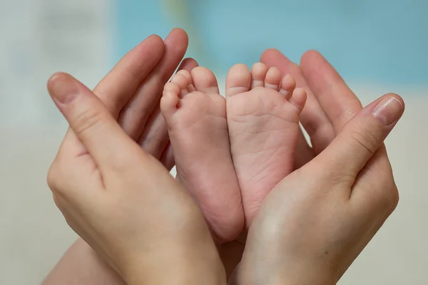 Madre che tiene i piedi del bambino — Foto Stock