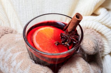 Kadınların elinde baharat ve narenciye ile sıcak şarap içmek. Noel pazarlarında ve fuarlarda içki içme kavramı.