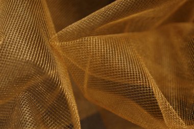 Tulle, dalgalı altın organza kumaşına yaklaş. yumuşak odak