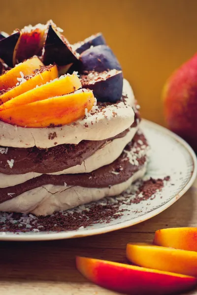 Meringue cake with chocolate cream, figs and peaches — Stock Photo, Image