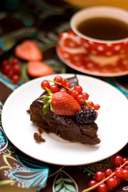 Slice of chocolate cake decorated with chocolate frosting and fresh berries clipart