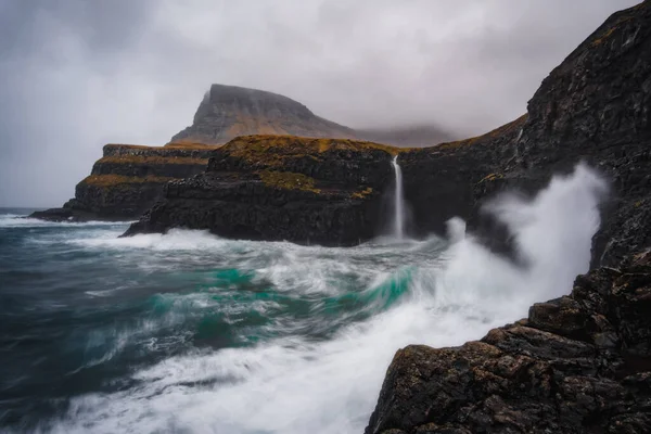 Vista dramática da cachoeira Mulafossur com a aldeia Gasadalur no fundo. Ilha Vagar, Ilhas Faroé, Dinamarca. novembro de 2021. — Fotografia de Stock