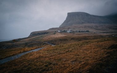 Vagar Adası 'ndaki Gasadalur manzarası. Bir tepenin yamacında küçük bir köy. Gasadalur, Faroe Adaları. Kasım 2021, dramatik manzara