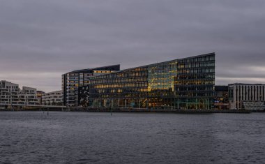 Aller Media AS genel merkezi, Kopenhag 'daki Havneholmen' deki fütürist karanlık bina, 2021 Kasım 'ında Danimarka. PLH Mimarlar tarafından tasarlandı. Bulutlu gün ve neredeyse tek renkli resim.