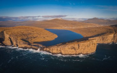 Danimarka 'nın Faroe Adaları, Vagar, Sunny Day' deki Traelanipan Uçurumu ve Sorvagsvatn Gölü 'nün panoramik hava manzarası. Okyanusun üstünde bir göl. Kasım 2021