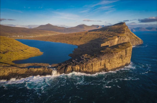 Danimarka 'nın Faroe Adaları, Vagar, Sunny Day' deki Traelanipan Uçurumu ve Sorvagsvatn Gölü 'nün panoramik hava manzarası. Okyanusun üstünde bir göl. Kasım 2021