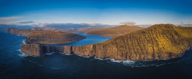 Danimarka 'nın Faroe Adaları, Vagar, Sunny Day' deki Traelanipan Uçurumu ve Sorvagsvatn Gölü 'nün panoramik hava manzarası. Okyanusun üstünde bir göl. Kasım 2021