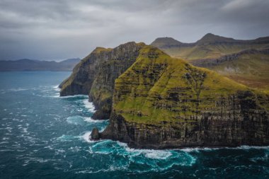 Nordradalur 'daki Faroe Adaları' nın devasa uçurumlarını yakalamak için Atlantik Okyanusu 'nun üzerinde bir dron uçurmak. Streymoy Adası, Kasım 2021