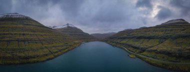 Faroe Adaları, Eysturoy Adası Vesturdalsa yakınlarındaki Elduvik civarında. Kasım 2021 'de dramatik bir hava vardı. Havadan panoramik dron görüntüsü.