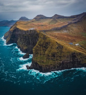 Nordradalur 'daki Faroe Adaları' nın devasa uçurumlarını yakalamak için Atlantik Okyanusu 'nun üzerinde bir dron uçurmak. Streymoy Adası, Kasım 2021