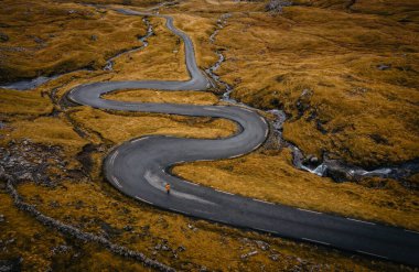 Nordradalur köyü yakınlarındaki Streymoy adasındaki yılan yolunda Koltur adası manzaralı bir hava manzarası. Faroe Adaları, Danimarka. Kasım 2021. Yalnız gezgin yılan yolunda