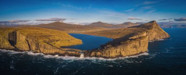 Danimarka 'nın Faroe Adaları, Vagar, Sunny Day' deki Traelanipan Uçurumu ve Sorvagsvatn Gölü 'nün panoramik hava manzarası. Okyanusun üstünde bir göl. Kasım 2021