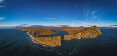 Danimarka 'nın Faroe Adaları, Vagar, Sunny Day' deki Traelanipan Uçurumu ve Sorvagsvatn Gölü 'nün panoramik hava manzarası. Okyanusun üstünde bir göl. Kasım 2021