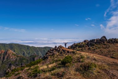 Uçlarda bir adam var. PICO DO ARIEIRO, MADEIRA - Ekim 2021: Güneşli bir sonbahar gününde Pico do Areeiro Arieiro 'dan Pico Ruivo' ya Madeira dağlarında yürüyüş yapan bir grup turist
