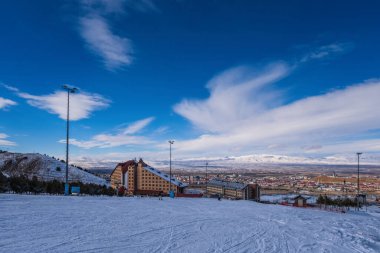 Palandoken Dağı, Erzurum Türkiye. Ocak 2021: Kayak pistleri ve kayak asansörleri. Karlı küçük çam ağaçları. Dağ kayağı ve snowboard. Palandoken dağından Erzurum otellerinin manzarası