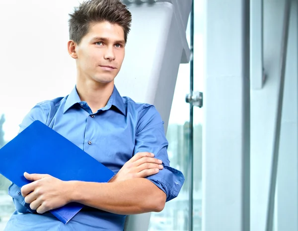 Joven hombre de negocios guapo con carpeta en la mano —  Fotos de Stock