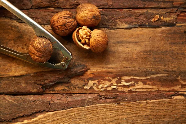 Nueces y cascanueces sobre fondo de madera —  Fotos de Stock