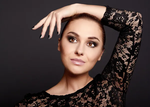 Portrait of beautiful brunette woman over dark background — Stock Photo, Image