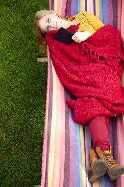 genç kadın bir hamakta dinlenme ve e-kitap okuma