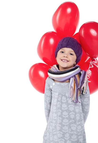 Linda niña sosteniendo un montón de globos rojos en forma de corazón —  Fotos de Stock