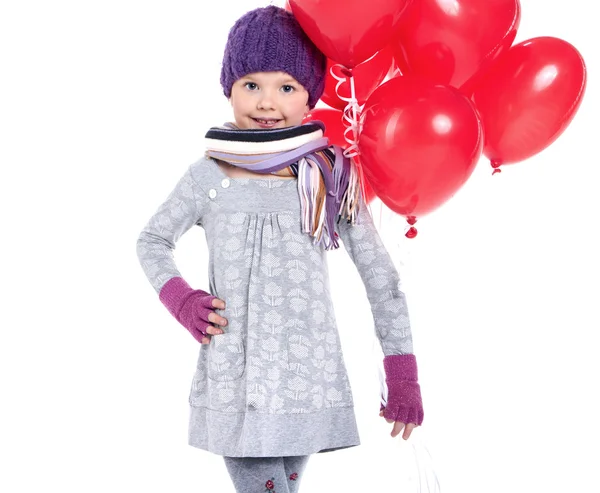 Linda niña sosteniendo un montón de globos rojos en forma de corazón —  Fotos de Stock