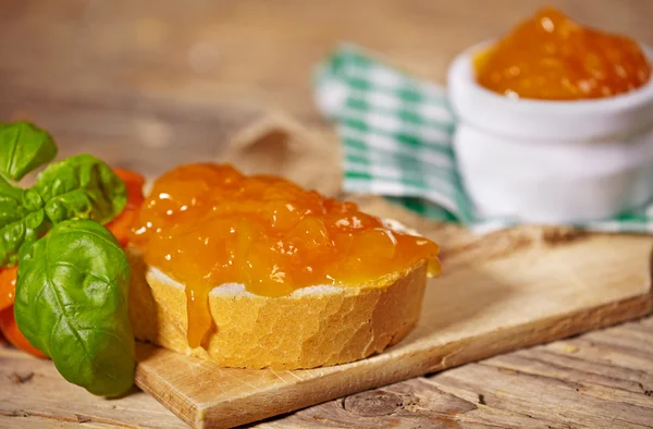Orangenmarmelade mit Brotscheibe auf Holztisch — Stockfoto