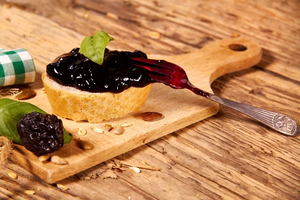 Marmellata di prugne con pane su tavola di legno — Foto Stock