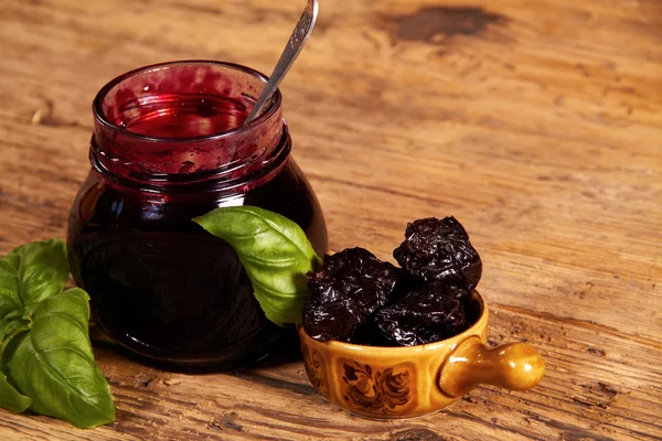 Glas hausgemachte Pflaumenmarmelade auf Holztisch — Stockfoto