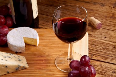 kırmızı bir kadeh şarap ve peynir 
