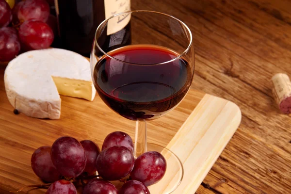 Ein rotes Glas Wein und Käse — Stockfoto