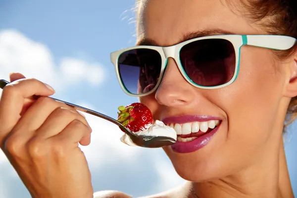 Healthy pretty girl tastes strawberries with whipped cream — Stock Photo, Image