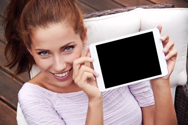 Mladá krásná žena ukazuje na tabletu — Stock fotografie
