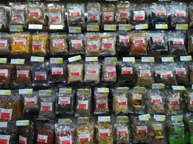 HATYAI, THAILAND - 11 Haziran 2020: Beyaz plastik poşetlere konan çeşitli ot ve baharatlar, Tayland etiketi ve hipermarketteki raflarda satılmak üzere sıralı olarak sergilenen sıralar