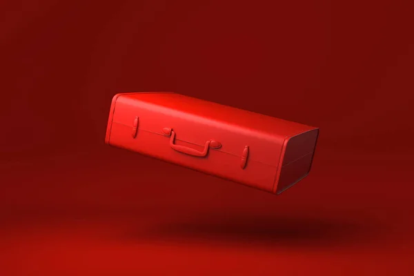赤い旅行スーツケースは赤い背景に浮かんでいます 創造性を最小限に抑えます モノクロだ 3Dレンダリング — ストック写真