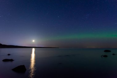 Aurora yeşilini göl üzerinde ay ile birleştirin.