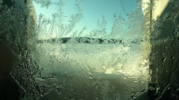 Cristales de hielo formados en un cristal de ventana en un día soleado — Foto de Stock
