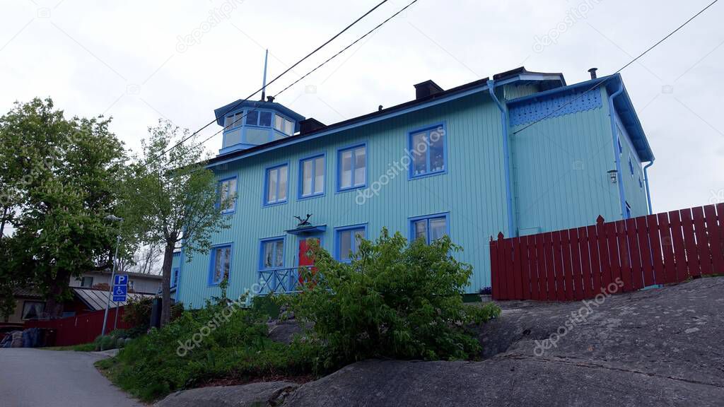 A blue painted wooden house in a village in the Stockholm region of Sweden.