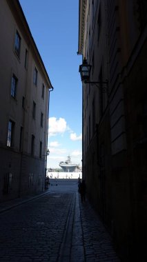 Stockholm, Sweden, June 4, 2022: A warship in the bay can be seen from a small street in the historic city center.